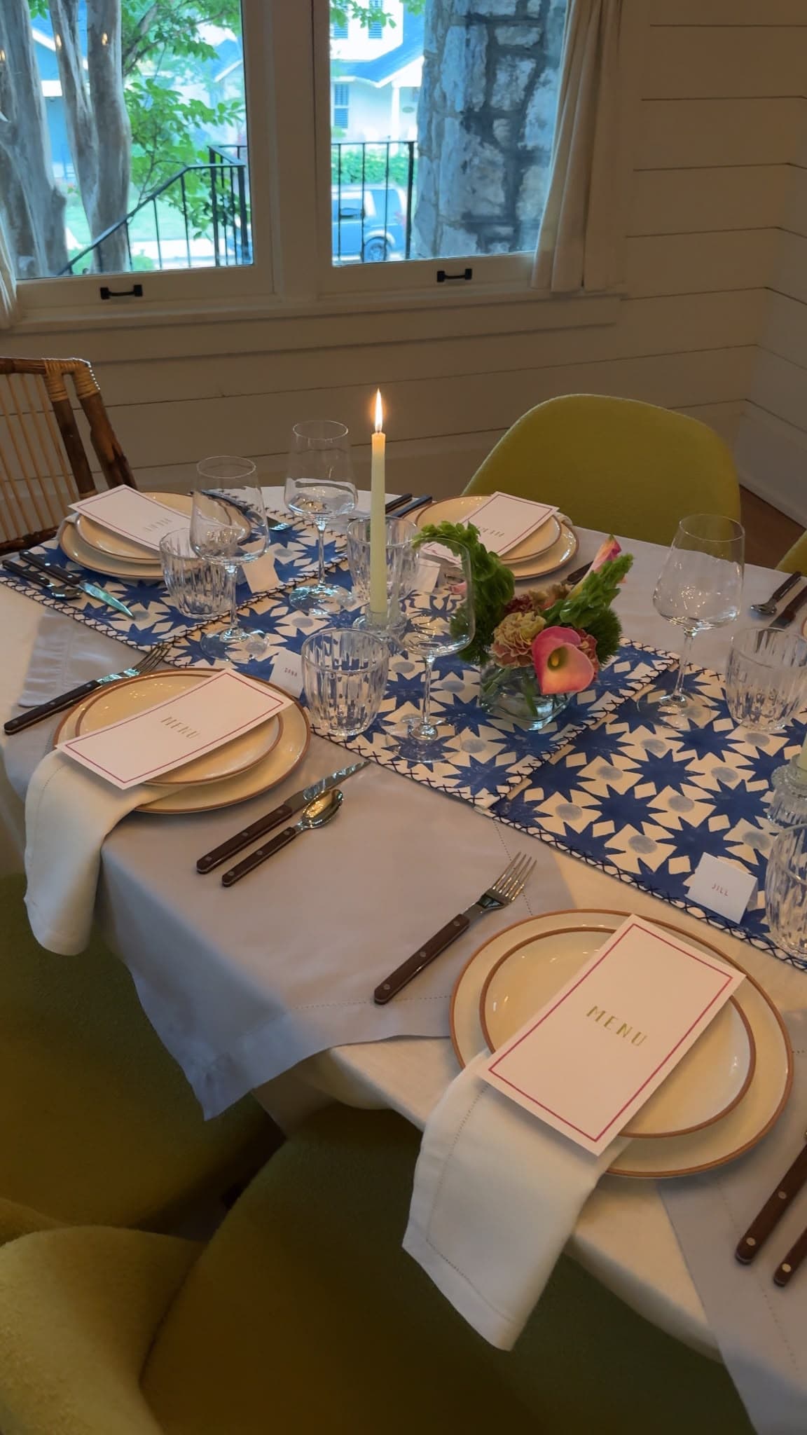 A table set with menus, a candle, and florals for a private e's supper club dinner