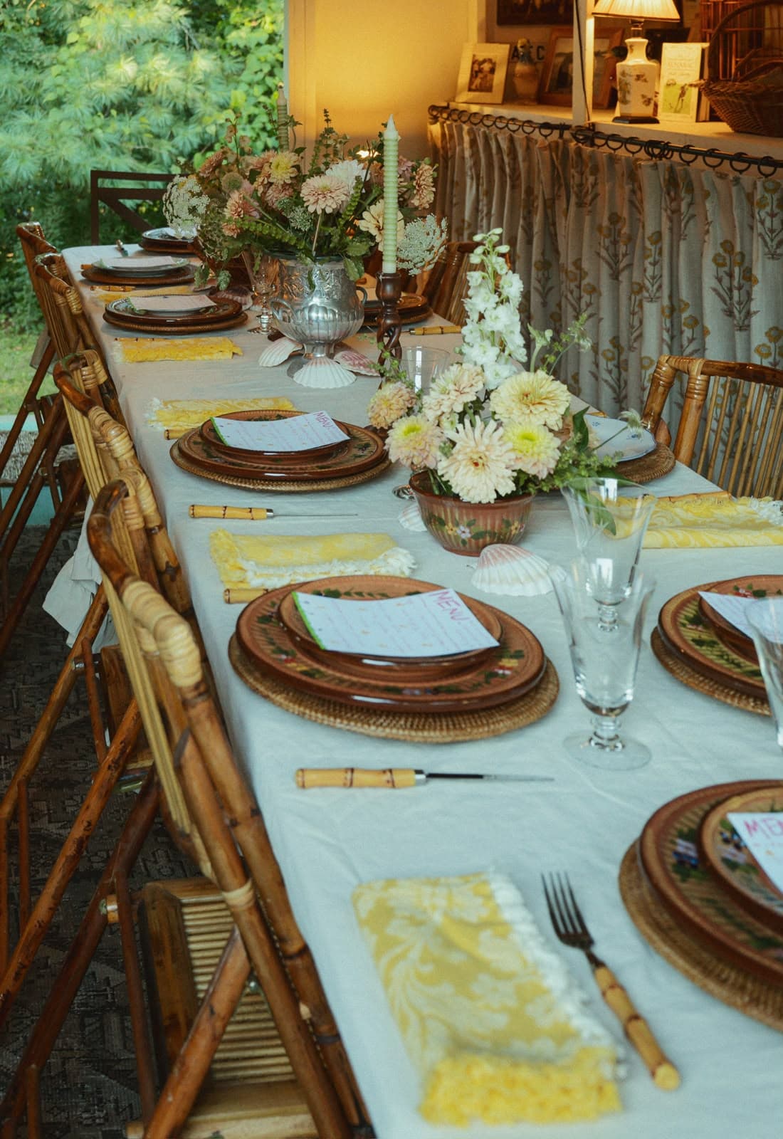 A long communal supper club table set for a seasonal dinner